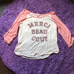 A shirt says MERCI BEAU COUP